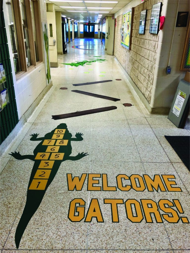 School hallway with sensory path and welcome gator graphic for children.