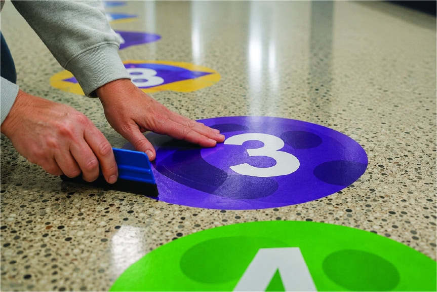 Person placing a number 3 marker on a sensory path floor.